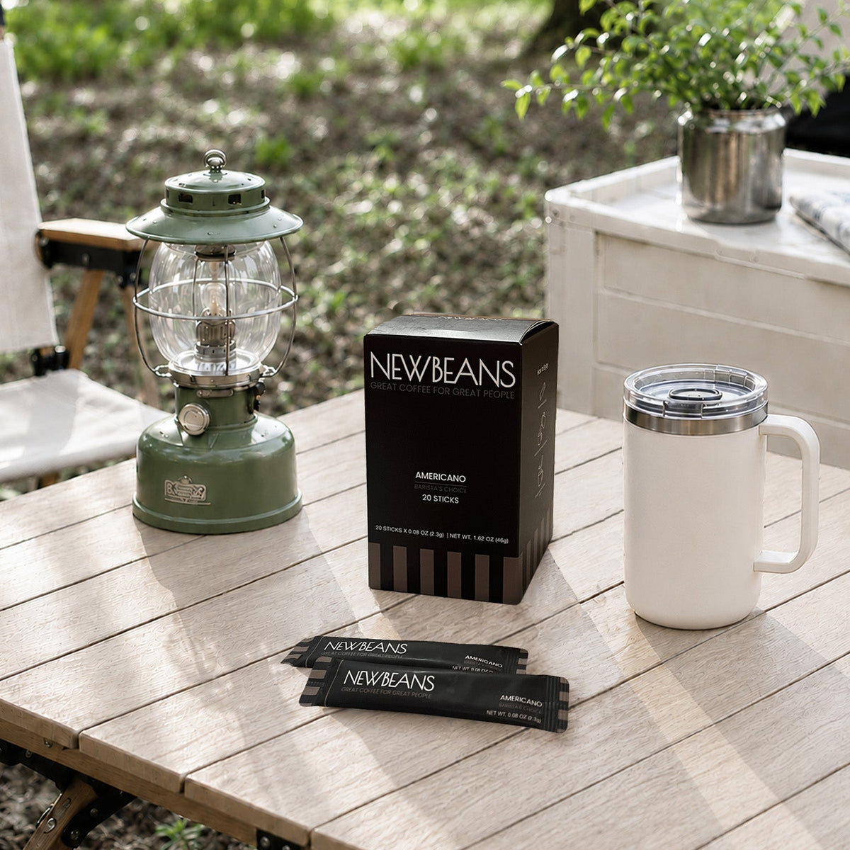 Newbeans Americano box and sticks on a camp table with a travel mug